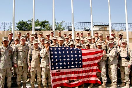 US Navy 080704-F-7045D-002 Sailors from Combined Security Transition Command-Afghanistan hold a vintage American flag with 48 stars, which was flown over Camp Eggers in Kabul, Afghanistan, to commemorate Fourth of July celebrat