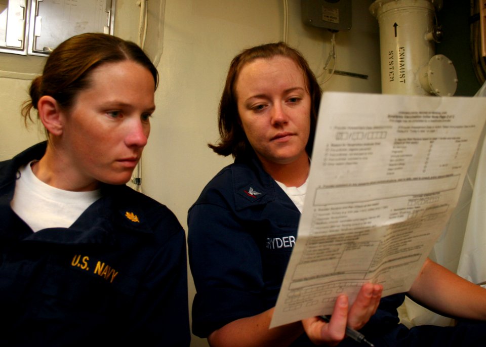 US Navy 080709-N-6764G-142 Lt. Noreen Murphy reviews medical forms with Hospital Corpsman 3rd Class Deanna Gryder aboard the amphibious transport dock ship USS San Antonio (LPD 17)