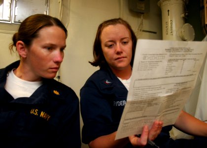 US Navy 080709-N-6764G-142 Lt. Noreen Murphy reviews medical forms with Hospital Corpsman 3rd Class Deanna Gryder aboard the amphibious transport dock ship USS San Antonio (LPD 17)