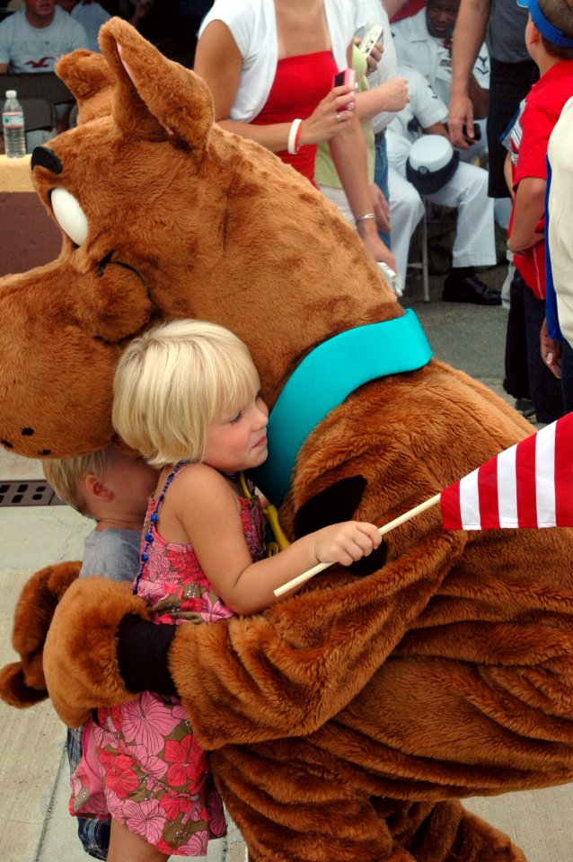 US Navy 080711-N-5307M-005 A Navy dependent hugs Scooby Doo while waiting for her father to return from a deployment aboard the amphibious assault ship USS Nassau (LHA 4)