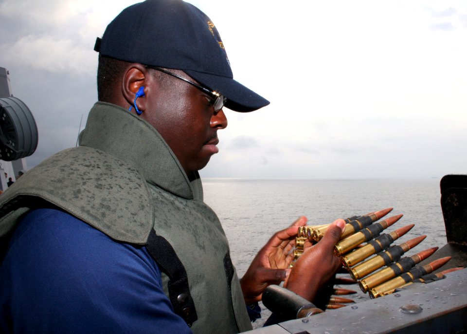 US Navy 080711-N-6764G-464 Fire Controlman 1st Class Kevin Sanders inspects the bullet feed for a .50-caliber machine gun during a warning and disabling fire exercise aboard the amphibious transport dock ship USS San Antonio (L