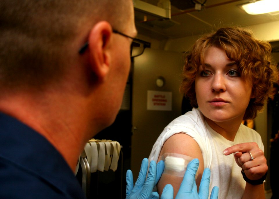 US Navy 080709-N-6764G-147 Seaman Lacey Bumstead, right, questions Hospital Corpsman 1st Class Steven Curran about her small pox vaccination aboard the amphibious transport dock ship USS San Antonio (LPD 17)