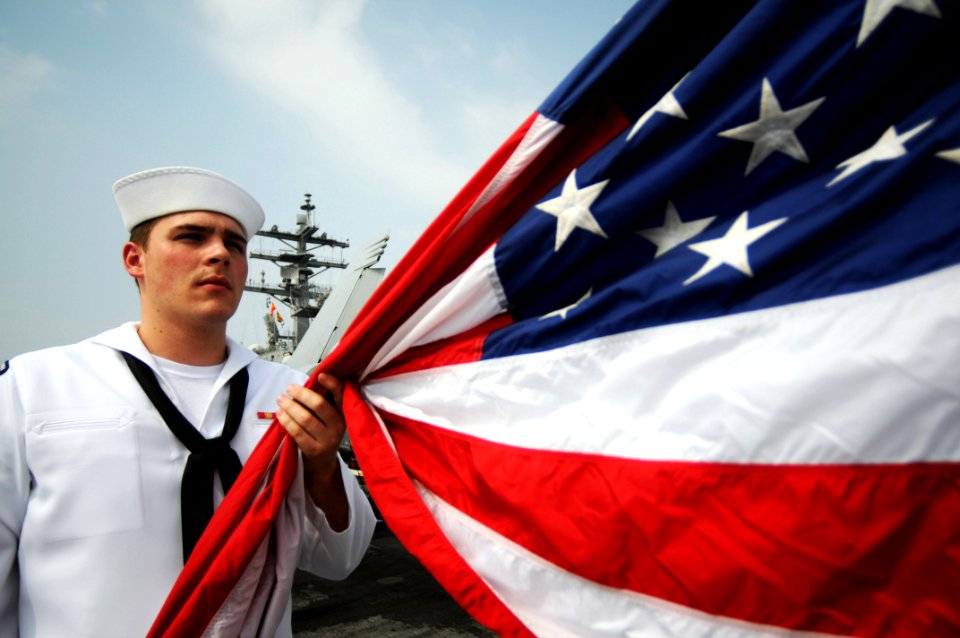 US Navy 080714-N-4009P-560 Information Systems Technician 2nd Class Ryan Allshouse, from Victorville, Calif., prepares to raise the national Ensign