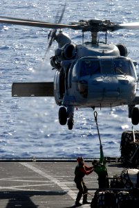 US Navy 080710-N-1635S-005 Personnel aboard the Military Sealift Command fast combat support ship USNS Bridge (T-AOE 10) attach a cargo pendant to an MH-60S Seahawk