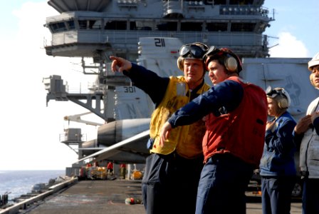 US Navy 080710-N-1635S-007 Boatswain's Mate 2nd Class Darrell Mccall, left, of Seguin, Texas, communicates to Gunner's Mate 2nd Class Anthony Castaneda, of Huntington Beach, Calif photo