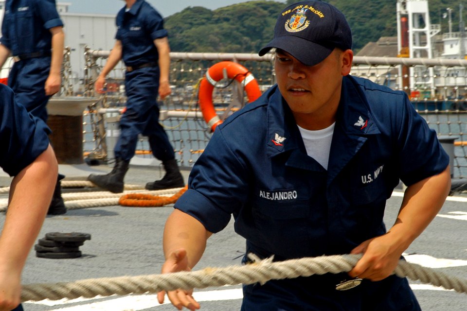 US Navy 080714-N-9123L-001 Interior Communications Electrician 3rd Class Mark Alejandro, from Lexington Park, Md., hauls in a mooring line