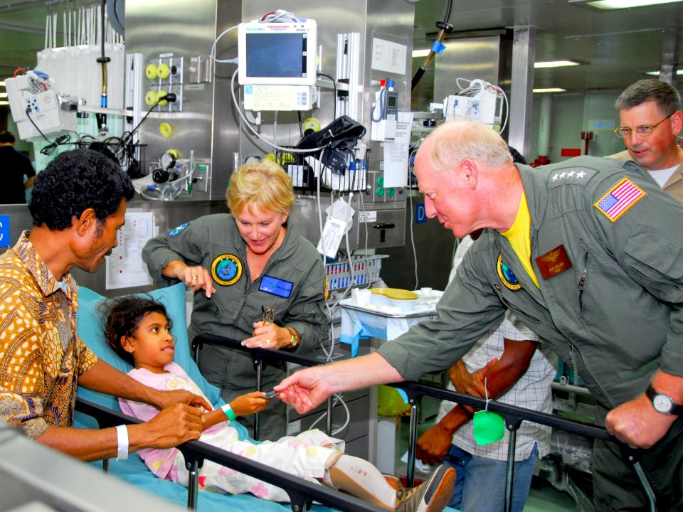 US Navy 080715-N-9689V-005 Adm. Robert Willard, commander of U.S. Pacific Fleet, and his wife, Donna Willard, give a command coin to a patient during a visit aboard the Military Sealift Command hospital ship USNS Mercy (T-AH 19