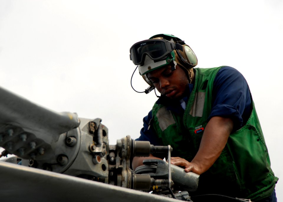 US Navy 080713-N-4236E-064 Aviation Electrician's Mate Airman Mario Smiley, assigned to Helicopter Anti-Submarine Squadron Light (HSL) 42 Det. 1, performs a corrosion prevention wash down on an SH-60B helicopter aboard the guid