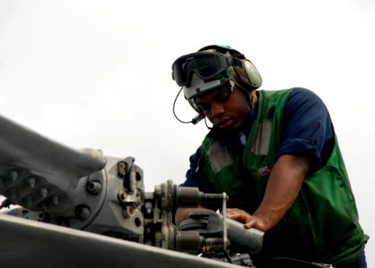 US Navy 080713-N-4236E-064 Aviation Electrician's Mate Airman Mario Smiley, assigned to Helicopter Anti-Submarine Squadron Light (HSL) 42 Det. 1, performs a corrosion prevention wash down on an SH-60B helicopter aboard the guid