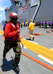 US Navy 080713-N-4856C-011 A Sailor runs to relieve a hose team member during a fire drill