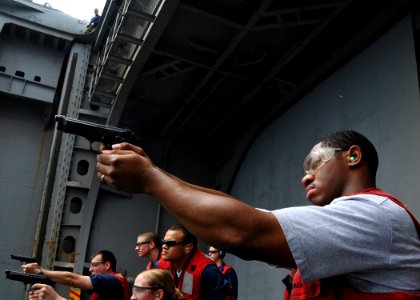 US Navy 080717-N-1745W-158 Aviation Machinist's Mate 3rd Class Conrad Grand, from Brooklyn, N.Y., fires a 9mm pistol during a live-fire exercise aboard the Nimitz-class aircraft carrier USS Abraham Lincoln (CVN 72) photo