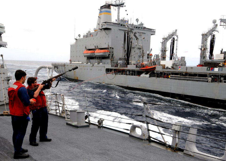 US Navy 080718-N-1082Z-015 unners Mate 2nd Class Edward McNelis and Gunners Mate 3rd Class John Sibirtzeff fire a guideline towards the fleet replenishment oiler USNS Leroy Grumman (T-AO 195) during a replenishment at sea