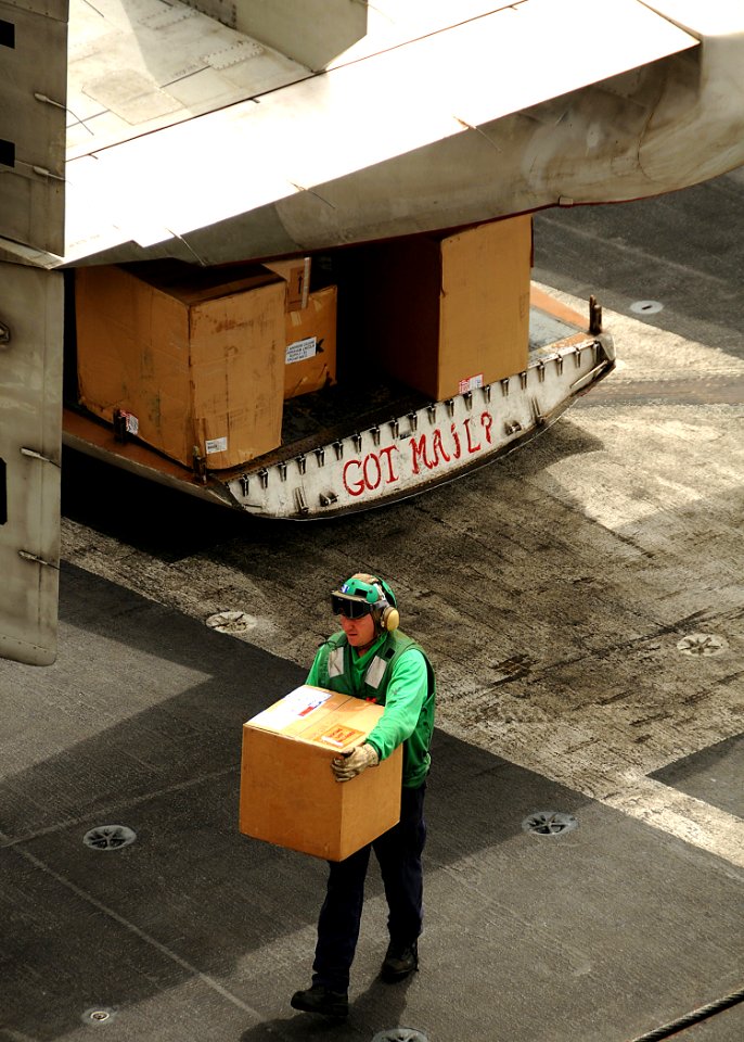 US Navy 080714-N-9898L-507 A Sailor assists in moving parcels from a C-2 Greyhound assigned to the