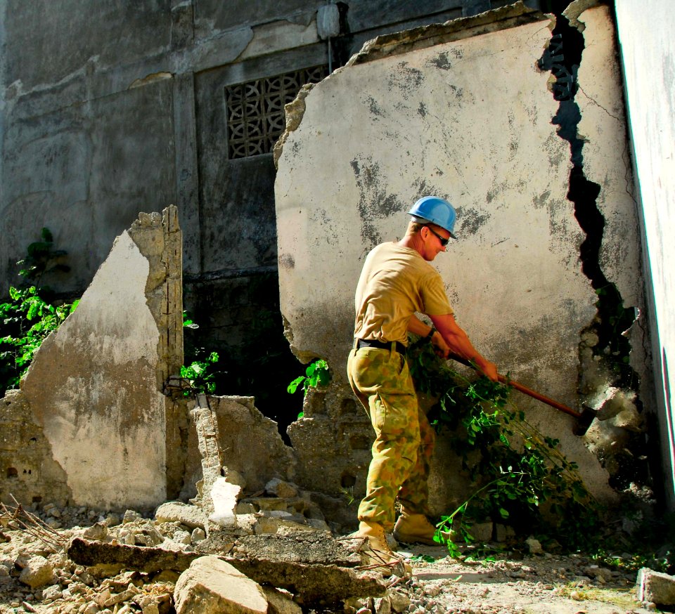 US Navy 080714-N-9689V-007 Sapper Kris Eyles, assigned to the Australian Army 3rd Combat Engineer Regiment, knocks down a wall during a Pacific Partnership engineering civic action program