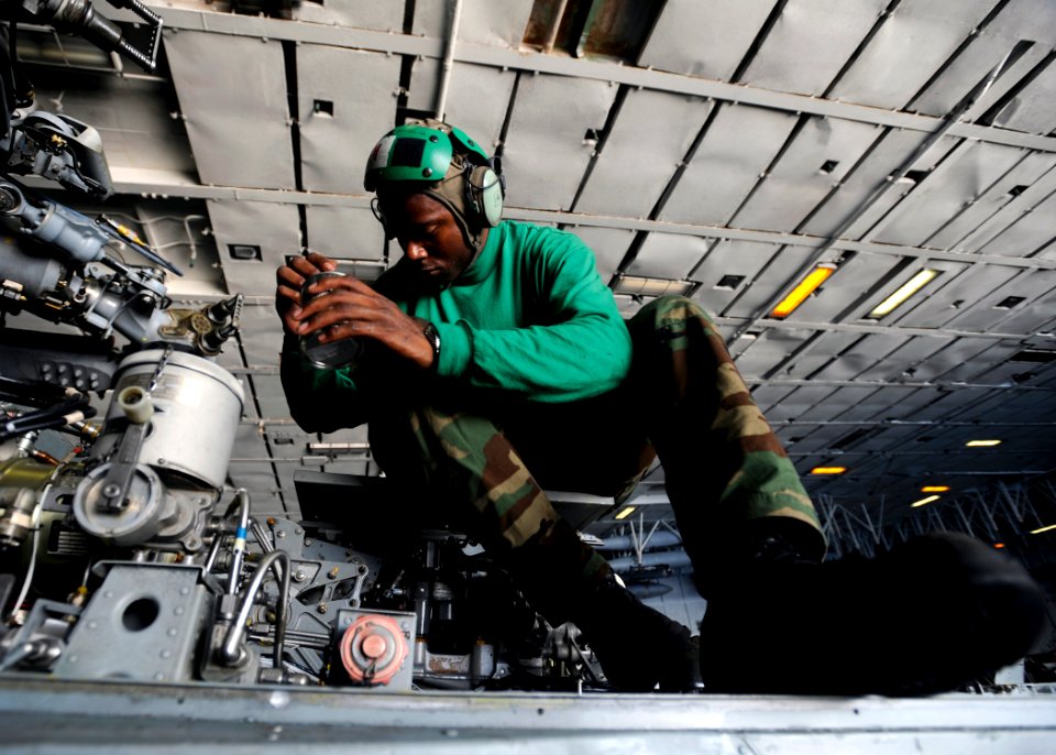 US Navy 080719-N-7241L-002 Aviation Structural Mechanic 1st Class Terrence Thompson of Helicopter Anti-Submarine Squadron (HS) 3 performs maintenance on the rotor assembly of an SH-60F Seahawk