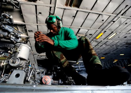 US Navy 080719-N-7241L-002 Aviation Structural Mechanic 1st Class Terrence Thompson of Helicopter Anti-Submarine Squadron (HS) 3 performs maintenance on the rotor assembly of an SH-60F Seahawk