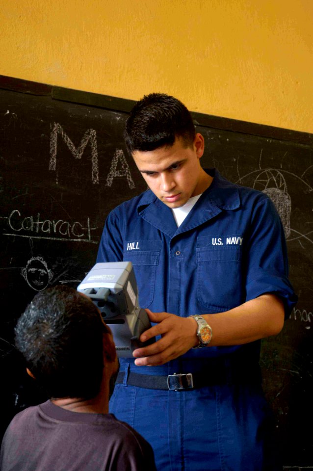 US Navy 080720-N-0209M-002 Ship's Serviceman Seaman Edward Hill, assigned to the Military Sealift Command medical ship USNS Mercy (T-AH 19) performs an eye scan on a patient during a Pacific Partnership 2008 medical civic actio