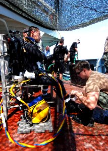 US Navy 080721-N-4044H-100 Builder 1st Class Jon Karulf prepares Lt. Li Ping Sung, executive officer of Underwater Construction Team (UCT) 1 and commander, Task Group 367.1.3, to enter the water