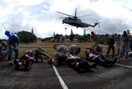 US Navy 080721-N-6674H-131 Service members and staff at Tripler Army Medical Center shield Sailorsacting as casualties from the downdraft of an MH-53 Sea Dragon