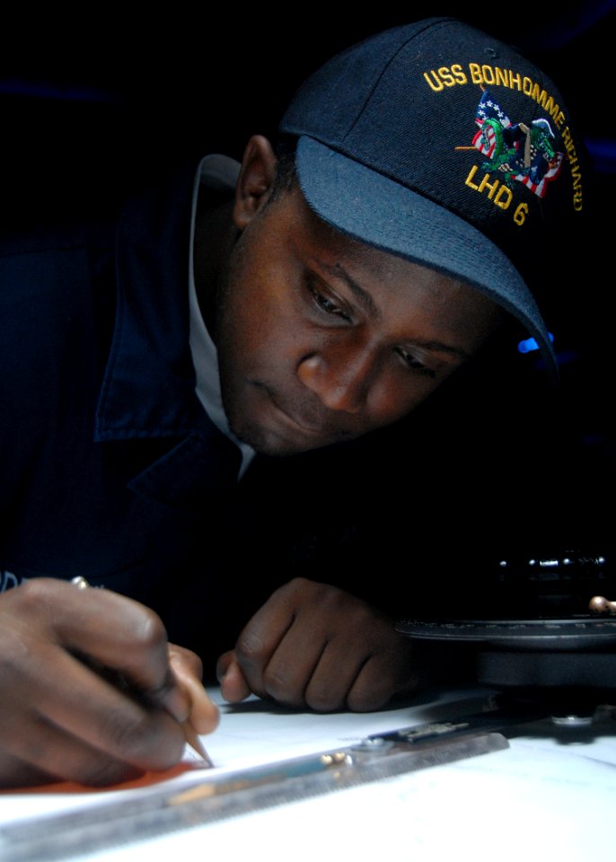 US Navy 080715-N-6999H-004 Operations Specialist Seaman David Maddrick III plots the course of the ship