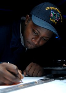 US Navy 080715-N-6999H-004 Operations Specialist Seaman David Maddrick III plots the course of the ship
