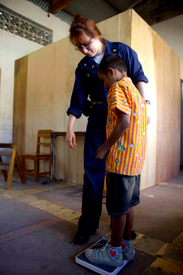 US Navy 080716-N-0209M-001 Cmdr. Rosemarie Tan weighs a patient at a Pacific Partnership medical civic action program at Nularn 1 Elementary School