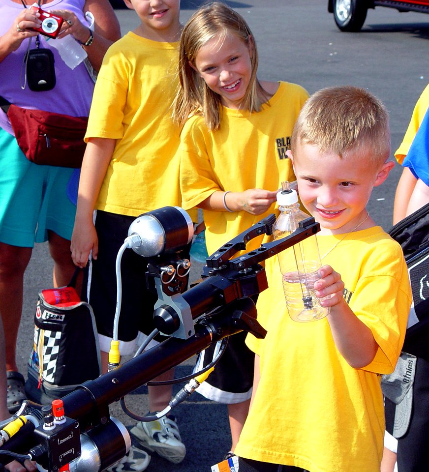 US Navy 080722-N-2888Q-008 A child takes a water bottle from a MK II Talon robot controlled by members of Explosive Ordnance Disposal (EOD) Mobile Company (MOB) 12 from Little Creek, Va., during an event for Delaware Navy Week