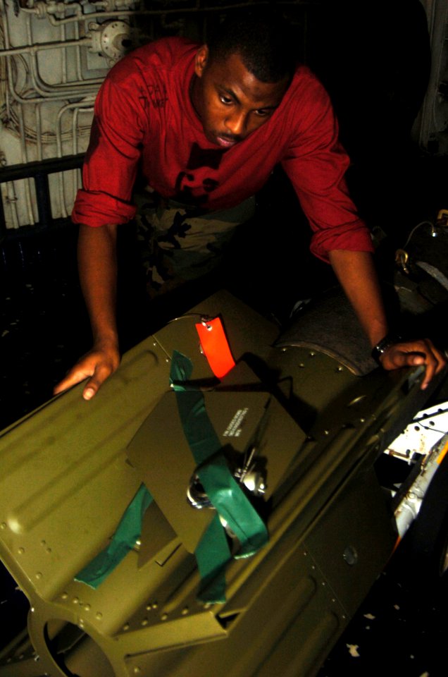 US Navy 080716-N-1062H-037 Aviation Ordnanceman Airman John Townes moves a Laser Guided Bomb Unit (GBU-16) into the aft bomb handling area elevator