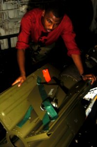 US Navy 080716-N-1062H-037 Aviation Ordnanceman Airman John Townes moves a Laser Guided Bomb Unit (GBU-16) into the aft bomb handling area elevator