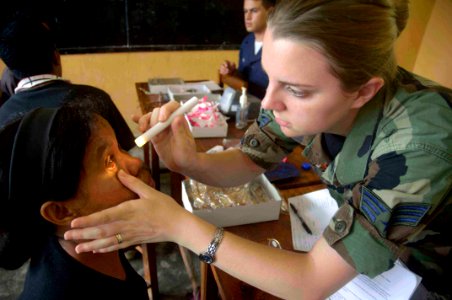 US Navy 080720-N-0209M-003 U.S. Air Force Senior Airman Kate Thomas, assigned to the Military Sealift Command medical ship USNS Mercy (T-AH 19) examines a patient during a Pacific Partnership 2008 medical civic action program