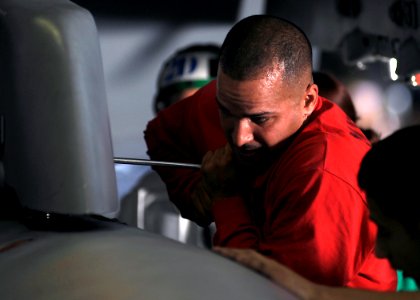 US Navy 080722-N-7241L-001 Aviation Ordnanceman 1st Class Hiran Carrero loosens a nut holding one of the fuel tanks of an F-A-18F Super Hornet