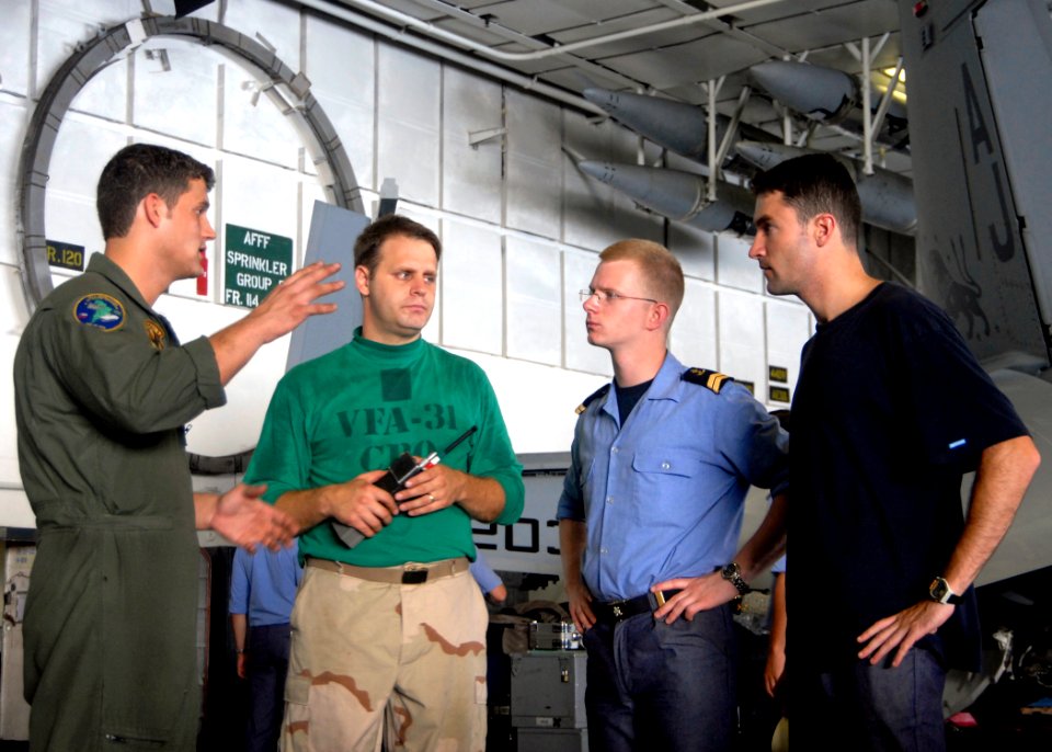 US Navy 080723-N-6676S-061 Chief Aviation Electrician's Mate Robert Colonna, center, and Aviation Machinist's Mate 3rd Class Josh Elmore, left, discuss the morning agenda