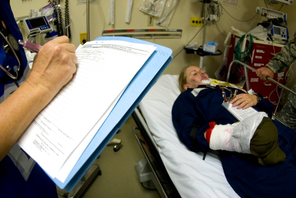 US Navy 080721-N-6674H-182 A medical doctor at Tripler Army Medical Center takes notes on Ensign Stacy Rinas