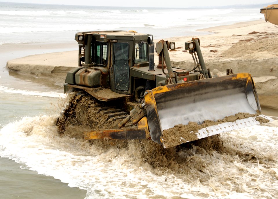 US Navy 080720-N-1424C-093 he force of the ocean rushes around the bulldozer as it digs a sand ramp at Gold Beach during Joint Logistics Over-The-Shore (JLOTS) 2008