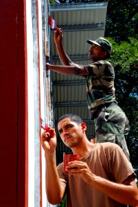 US Navy 080720-N-9689V-001 Steelworker 3rd Class Jonah Soto and Indian Army Cpl. Kallaseril Vinu paint window frames