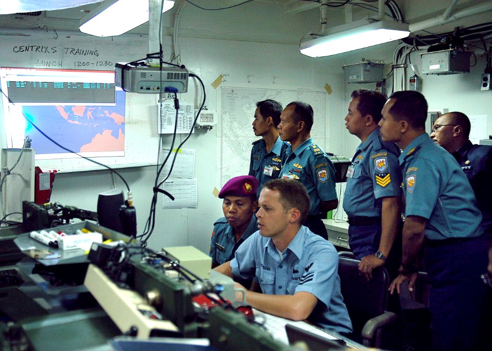 US Navy 080721-N-3446M-011 Electronics Technician 1st Class Joshua Hoeksema of Commander, Logistics Group Western Pacific, explains the combined enterprise network regional information exchange system