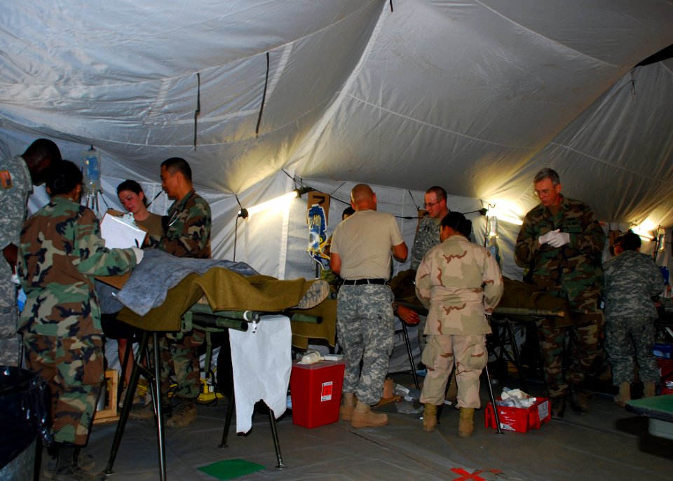 US Navy 080721-N-4973M-138 Army and Navy medical staff treat simulated patients inside the Camp Peguero Battle Aide Station during a mass casualty drill