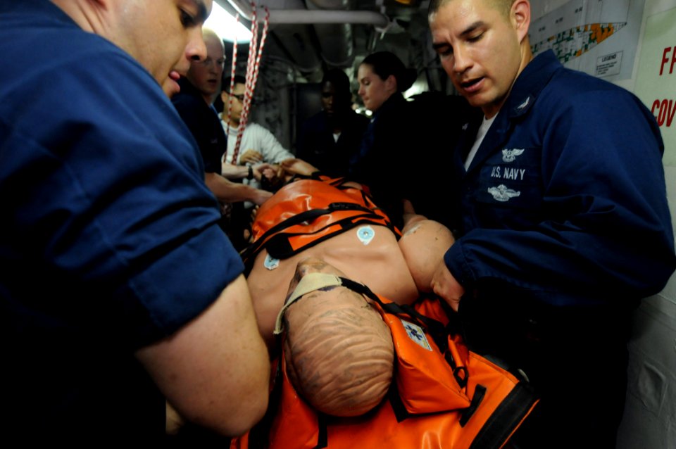 US Navy 080725-N-3659B-042 Hospital Corpsman 3rd Class Robert Valtierra, right, from Stockton, Calif., and Hospital Corpsman 3rd Class Christopher Williams, from San Diego, along with other Medical Response Team personnel, carr