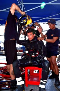 US Navy 080722-N-3446M-025 Navy Diver 2nd Class Christopher Peek, assigned to Mobile Diving and Salvage Unit (MDSU) 1 and members of the Indonesian navy dive team help Senior Chief Navy Diver Paul Adams don his head gear before
