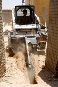 US Navy 080728-N-9623R-005 Equipment Operator 3rd Class Zachariah Almaraz uses a trencher to dig path for cables at a Al Qaim construction site