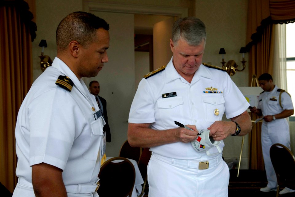 US Navy 080724-N-8273J-103 Chief of Naval Operations (CNO) Adm. Gary Roughead signs ballcaps and coffee mugs during the 36th Annual National Naval Officers Association professional development and training conference