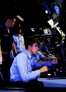 US Navy 080729-N-9520G-029 Ensign Kyle Muller, fire control officer looks on as Fire Controlman 2nd Class Ryan Pavelich receives reports during a mock naval surface fire support training exercise