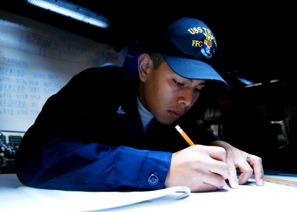 US Navy 080731-N-9520G-027 Operations Specialist 3rd Class Allan Tay records target bearings during a mock Naval Surface Fire Support exercise