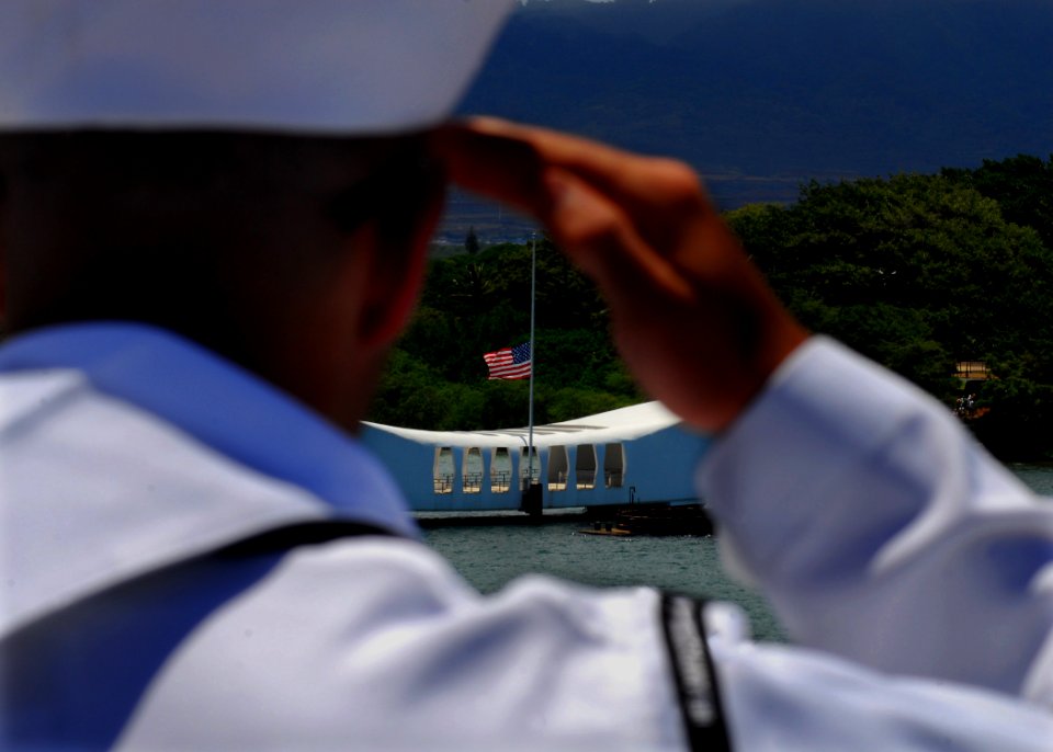 US Navy 080801-N-2638R-002 Aviation Warfare Systems Operator 2nd Class Dallas Cook, from Heath, Ohio, salutes the USS Arizona Memorial from the flight deck of the aircraft carrier USS Kitty Hawk (CV 63)
