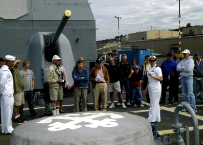 US Navy 080731-N-4649C-003 Ensign Samantha Foxton describes the ship's anchor assembly to a tour group on the ship's foc'scle photo