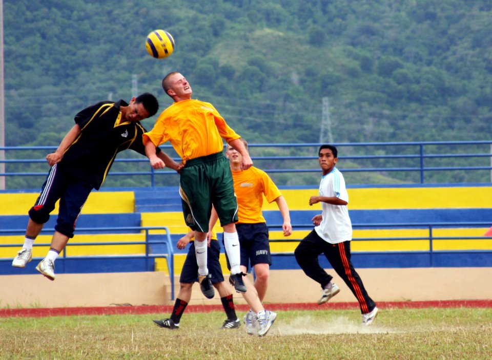 US Navy 080806-N-7031M-305 Gunner's Mate 2nd Class James Duggan, a guided-missile destroyer USS Curtis Wilbur (DDG 54) Sailor, and a Royal Malaysian Navy sailor rise above the rest in a friendly game of soccer