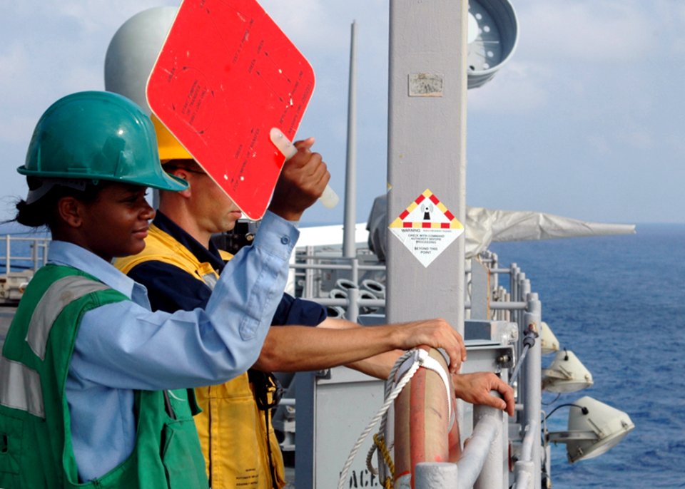 US Navy 080729-N-9134V-102 Seaman Noelle Gilchrist uses a signal paddle during a replenishment at sea