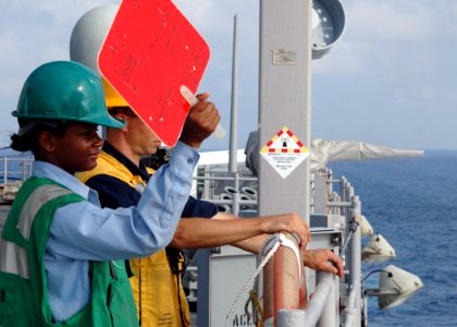 US Navy 080729-N-9134V-102 Seaman Noelle Gilchrist uses a signal paddle during a replenishment at sea