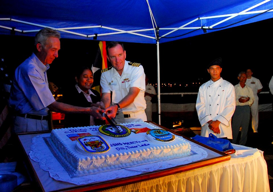 US Navy 080724-N-9689V-007 The Honorable Hans G. Klemm, Maria Paixao, and Capt. William A. Kearns III cut a cake during a farewell reception