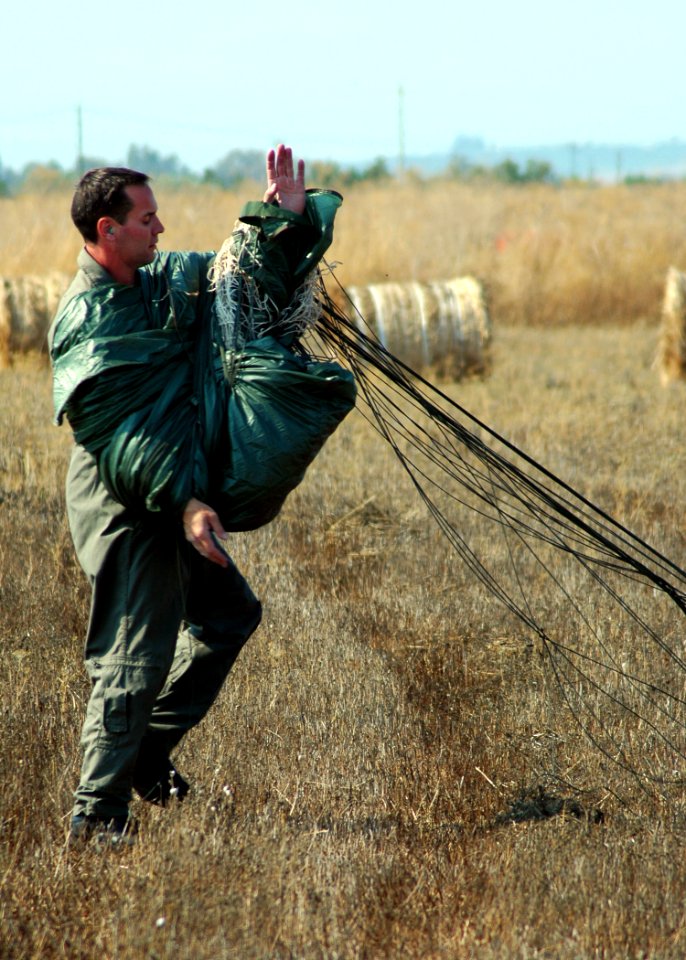 US Navy 080730-N-0577G-040 Cmdr. Todd Siddall, commanding officer of Explosive Ordnance Mobile Unit Eight (EODMU) 8, gathers his parachute after a static line parachute jump over Naval Air Station Sigonella